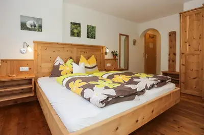 a bedroom with a large bed with yellow and brown blankets at Oberpalwitterhof in Barbiano