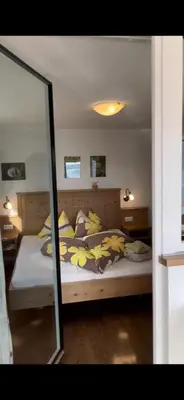 a bedroom with a large bed with a mirror at Oberpalwitterhof in Barbiano