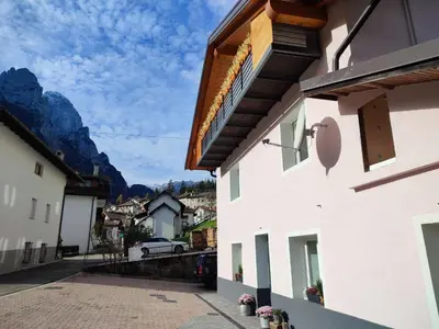 a view from the side of a building with mountains in the background at Sweet Dolomites Sauna & Jacuzzi in Agordo