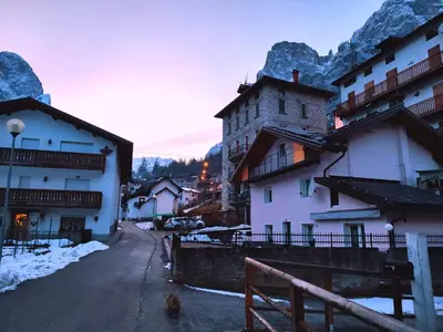 a group of buildings on a street with snow at Sweet Dolomites Sauna & Jacuzzi in Agordo