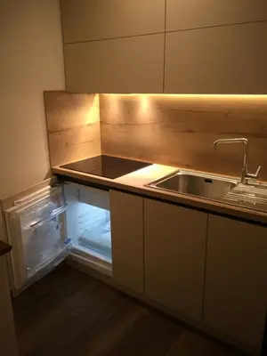 an empty kitchen with a sink and an open refrigerator at Ciasa Pascal in San Vigilio
