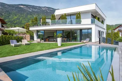 a villa with a swimming pool in front of a house at Villa Aich in Appiano sulla Strada del Vino
