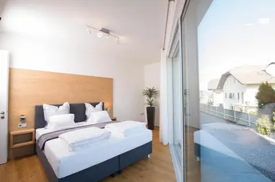 a bedroom with a large bed and a balcony at Villa Aich in Appiano sulla Strada del Vino