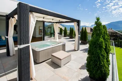 a hot tub on a patio with a gazebo at Villa Aich in Appiano sulla Strada del Vino