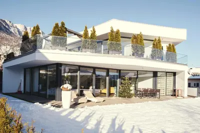 a house in the mountains with snow on the ground at Villa Aich in Appiano sulla Strada del Vino