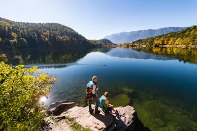 two people standing on a rock near a body of water at Villa Aich in Appiano sulla Strada del Vino