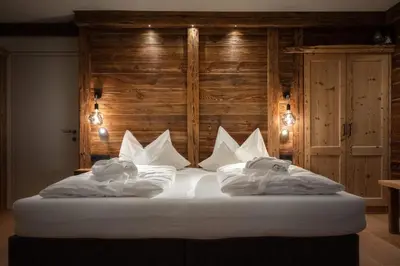 a bed with white sheets and pillows in a room at Apartment Scurcià 41 in Ortisei
