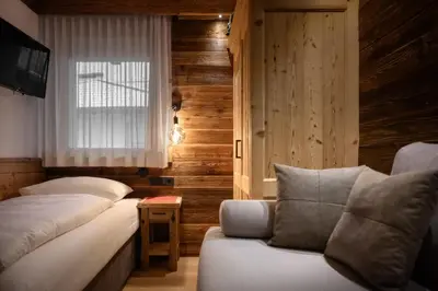 a large bedroom with a large bed and a couch at Apartment Scurcià 41 in Ortisei