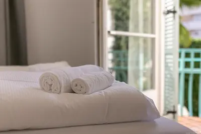 a stack of towels on a bed with a window at Apartment Central in Bolzano