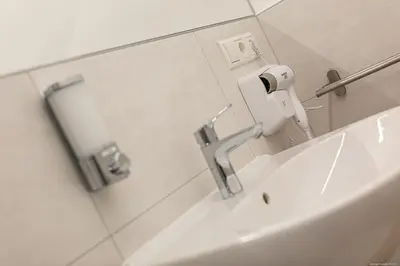 a bathroom with a sink and a toilet paper dispenser at Apartment Central in Bolzano