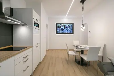 a kitchen and dining room with a table and chairs at Apartment Central in Bolzano