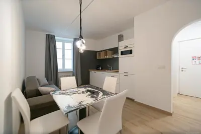 a kitchen and a living room with a table and chairs at Apartment Central in Bolzano