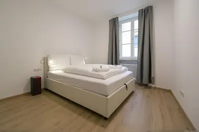 a white bed in a room with a window at Apartment Central in Bolzano