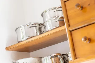 a row of pots and pans on a wooden shelf at Villa Suredl in Ortisei