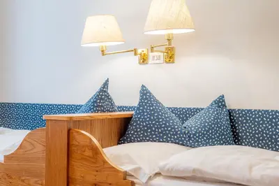 a bedroom with blue and white pillows on a bed at Villa Suredl in Ortisei