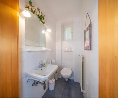 a white bathroom with a sink and a toilet at Villa Suredl in Ortisei