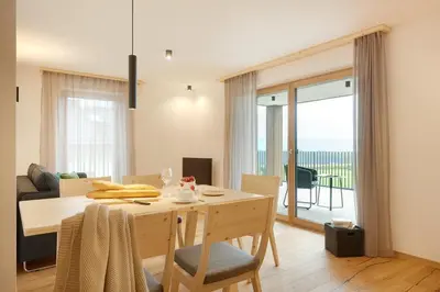 a dining room with a table with a view of the ocean at Ariala - Mountain Holiday Home in Falzes