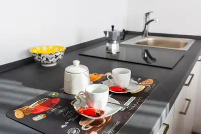 a kitchen counter with two cups and plates on it at Lara's Guesthouse in Merano