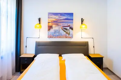 a bedroom with two beds and a painting on the wall at Lara's Guesthouse in Merano