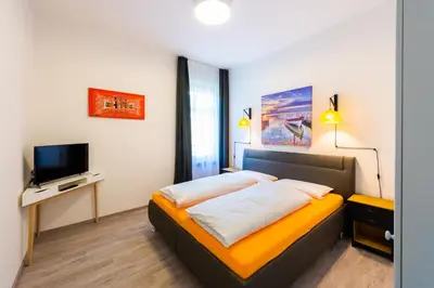a bedroom with a bed and a flat screen tv at Lara's Guesthouse in Merano