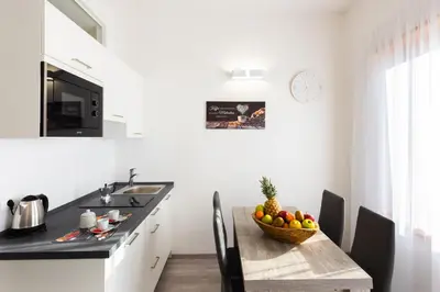 a kitchen with a table with a bowl of fruit on it at Lara's Guesthouse in Merano