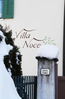 a snow covered mailbox in front of a fence at Villa Noce 2 in Tesero