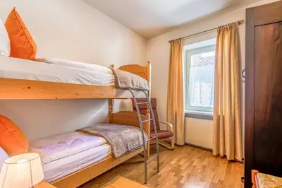 a bedroom with two bunk beds and a window at Villa Noce 2 in Tesero