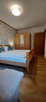 a large bedroom with two beds and a window at Villa Noce 2 in Tesero