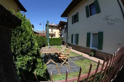 a table and chairs in front of a building at Villa Noce 1 in Tesero