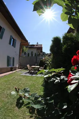 a house with a yard with a table and flowers at Villa Noce 1 in Tesero