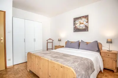 a bedroom with a large bed with blue pillows at Villa Noce 1 in Tesero