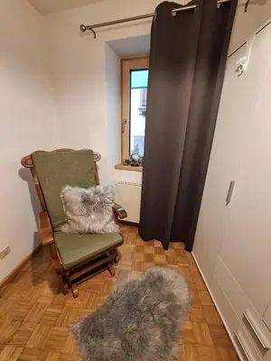 a room with a chair with a furry pillow on it at Villa Noce 1 in Tesero