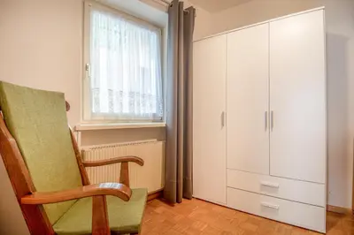 a living room with a chair and a cabinet at Villa Noce 1 in Tesero