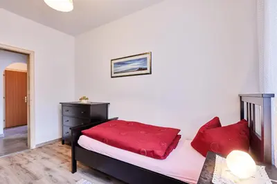 a bedroom with a bed with red pillows at Apartmenthaus Haringer in Novacella