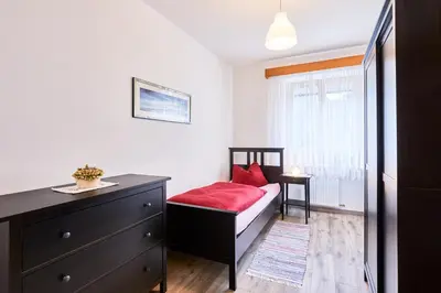 a bedroom with a bed and a dresser and a window at Apartmenthaus Haringer in Novacella