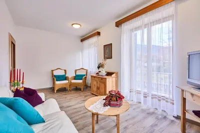 a living room with a couch and a tv at Apartmenthaus Haringer in Novacella