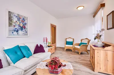 a living room with a white couch and a table at Apartmenthaus Haringer in Novacella