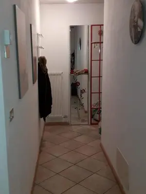 a room with a hallway with a tile floor at Le betulle in Predazzo