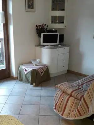 a living room with a tv and a table in a room at Le betulle in Predazzo