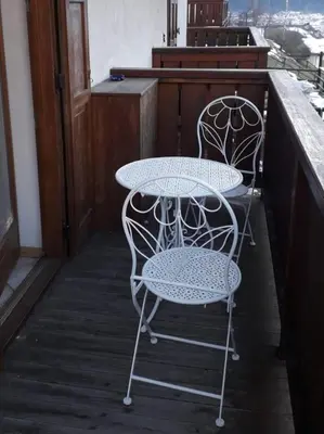 two chairs and a table on a porch at Le betulle in Predazzo