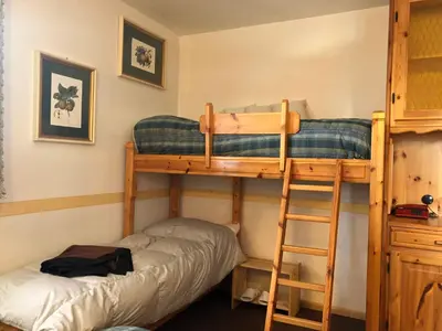 two bunk beds in a room with a ladder at Mellon House in Falcade