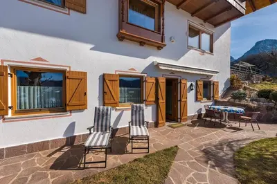 a patio with chairs and a table and a house at App. Eichenheim in Fiè
