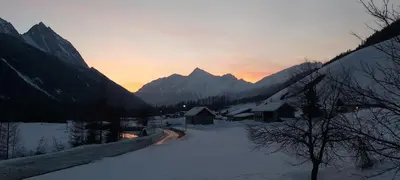a snow covered mountain range with a sunset in the background at Blasighof in Quinzo