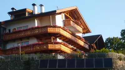 a house with wooden balconies and flowers on it at Bio Kräuterhof Oberpalwitter in Barbiano