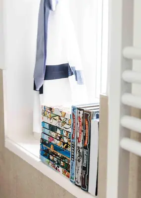 a shelf with dvds and books on a window sill at Delightful Villa Rina in Merano