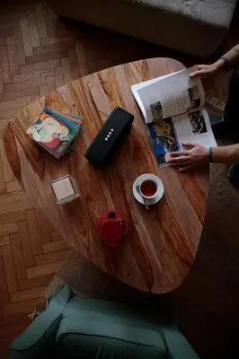 a round wooden table with a book and a laptop at Delightful Villa Rina in Merano