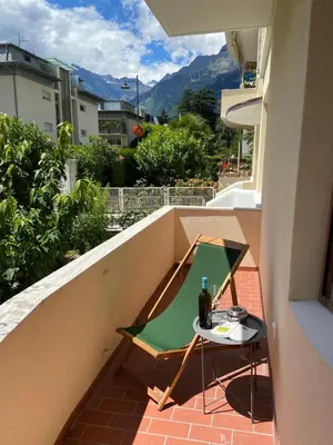 a table on a balcony with a bottle of wine at Delightful Villa Rina in Merano