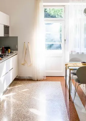 a kitchen with a white door and a table at Delightful Villa Rina in Merano