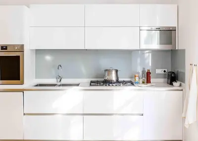 a white kitchen with white cabinets and a sink at Delightful Villa Rina in Merano
