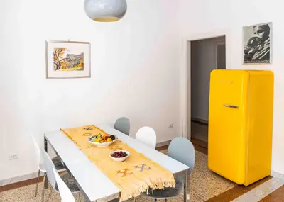 a dining room with a table and a yellow refrigerator at Delightful Villa Rina in Merano